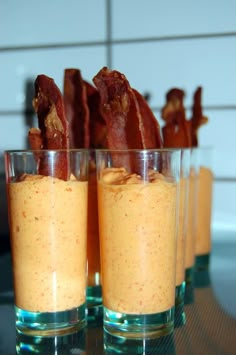 two glasses filled with food sitting on top of a table