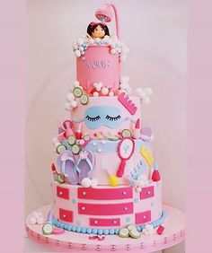 a three tiered cake decorated with pink and blue decorations