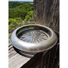 a metal bowl sitting on top of a wooden fence