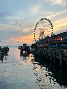 a ferris wheel sitting on top of a pier next to the ocean