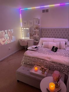 a bedroom with a bed, desk and television in it's corner area at night