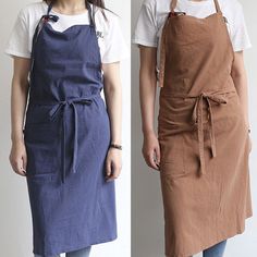 two women wearing aprons standing next to each other in front of a white wall