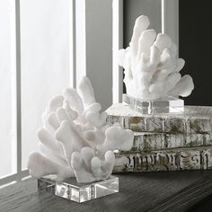 a stack of books sitting on top of a wooden table next to a vase filled with white flowers