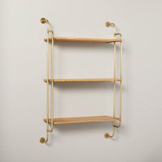 a wall mounted shelf with two shelves on each side and gold metal brackets at the bottom