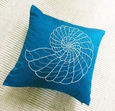 a blue pillow with a white flower on it