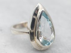 "This ring is crafted from high-quality sterling silver and features a stunning pear cut blue topaz. The pear cut gives the gemstone an extra sparkle, perfect for any special occasion. Metal: Sterling Silver Gem: Blue Topaz Gem Measurements: 9.0 x 17.3 mm, Pear Cut Ring Size: 7 Marks: \"STER\" Stamped on the inside band SKU #: A27999 Each piece has been identified and graded by a Graduate Gemologist who has been certified by the Gemological Institute of America (GIA). We have six brick-and-morta Fine Jewelry Blue Topaz Teardrop Rings, Fine Jewelry Pear-shaped Topaz Ring, Sterling Silver Pear-shaped Topaz Ring For Anniversary, Fine Jewelry Blue Topaz Pear-shaped Ring, Elegant Teardrop Topaz Ring In Sterling Silver, Pear-shaped Blue Topaz Ring For Gift, Pear-shaped Blue Topaz Ring With Accent Stones, Anniversary Blue Topaz Teardrop Ring, Anniversary Teardrop Blue Topaz Ring