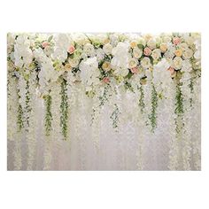 white flowers and greenery are arranged on a backdrop for an event or wedding reception