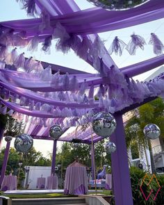 purple and silver decorations are hanging from the ceiling