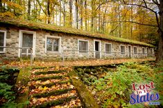 an old stone building surrounded by trees and leaves