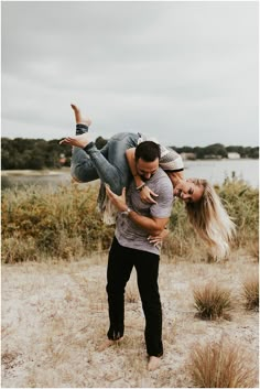 a man carrying a woman on his back in the middle of an open field with grass