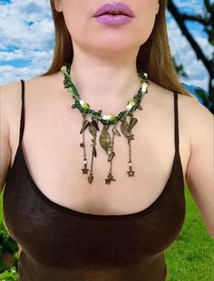 This Amazing Twisted  Woodland Necklace  with Charms nature  inspired. Perfect Necklace for Renaissance Festival  Celtic wedding or  everyday wear. Handmade item  Materials: Pendant  Leaf charms different sizes, Crystal rondelle and bicone beads, Mushroom beads, antique bronze  chain,  pinecones  Item details Materials: antique bronze findings, Crystal Bicone, Green Rondelle Beads ,Curb Chain , Leaf Pendant, green mushrooms beads , spike beads Czech glass, and other charms  Style: Celtic, Bohemi Goblincore Crafts Necklaces, Mushroom Necklace Bead, Hippie Mushroom Necklace, Beads Mushroom, Mushroom Beads, Twisted Necklace, Pinecone Necklace, Fairy Cosplay, Celtic Wedding