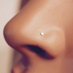 a close up view of a nose with a small pearl on it's side