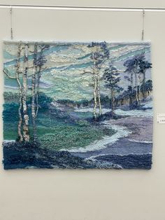 a tapestry hanging on a wall with trees in the background