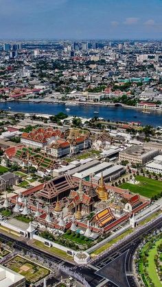 an aerial view of a large city with lots of buildings and water in the background