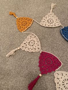 four crocheted doily with tassels on the floor