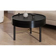 a black coffee table sitting on top of a hard wood floor next to a couch