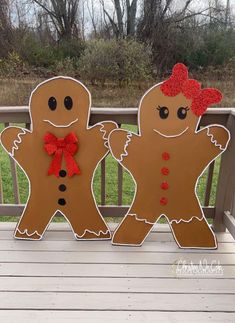 two gingerbread man and woman standing on a porch