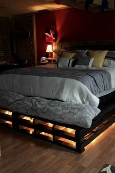 a bed made out of pallets with lights on the bottom and headboard, in a bedroom