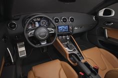 the interior of an audi car with brown leather and black trims, including steering wheel