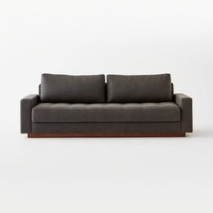 a gray couch sitting on top of a white floor