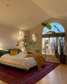 a bedroom with a large bed sitting on top of a red rug next to a window