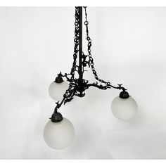 an old fashioned chandelier with three glass globes hanging from it's chain