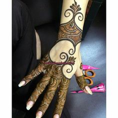 a woman's hand with henna tattoos on it