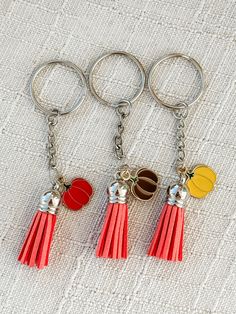 three key chains with charms attached to them