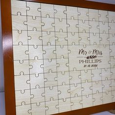 a wooden jigsaw puzzle with the names and date on it, as well as an image of a couple's wedding date