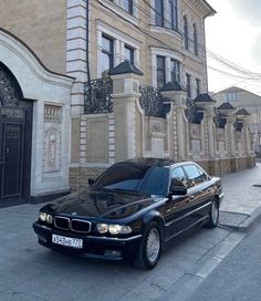 a black car is parked in front of a building on the side of the street