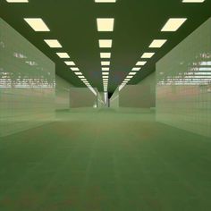 an empty room filled with lots of white tiles and green flooring in the middle