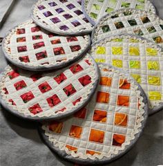 four quilted coasters are sitting on a table