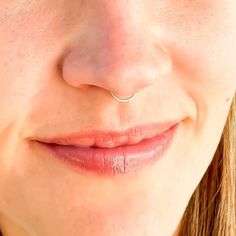 a close up of a woman's face with a nose piercing