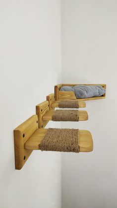 three wooden shelves with mattresses on them in a corner next to a white wall