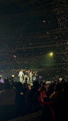 a group of people standing on top of a stage with confetti flying in the air