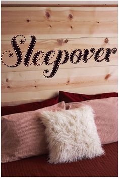 a wooden headboard with the word sleepover spelled in cursive letters on it