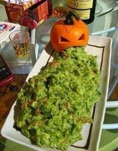 a white plate topped with guacamole and a jack - o'- lantern