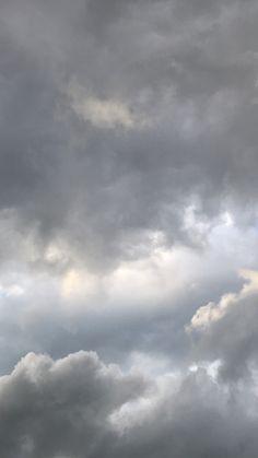 an airplane is flying in the cloudy sky