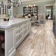 a large kitchen with white cabinets and marble counter tops