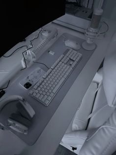 a computer keyboard and mouse sitting on a desk with white leather chairs in front of it