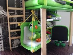 there is a green bird bed in the room with bunk beds and ladders on the wall