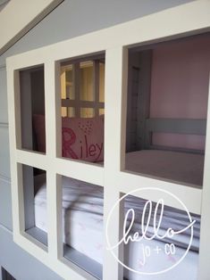 the bunk bed is made out of white wood and has four windows on each side