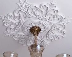 an ornately decorated ceiling with three silver cups on the top and one gold cup in the middle