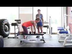 a man and woman doing squats on a bench in a gym with exercise equipment