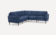 a blue sectional couch with wooden legs