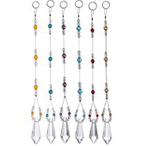 a set of seven glass beaded necklaces hanging from hooks on a white background