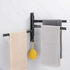 two towels hanging on the wall next to each other with a yellow ball dangling from it