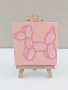 an easel with a pink painting on it