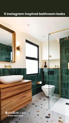 a bathroom with green tile and wooden vanity, mirror, toilet and bathtub in it