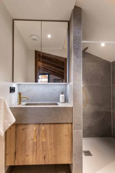 a bathroom with a sink, mirror and shower stall in the corner next to it